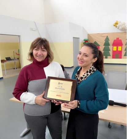 22/01/2026: la dott.ssa Chiara Marinò, coordinatrice del Progetto Giornalista per un giorno, mentre consegna la targa e la Borsa di studio alla Dirigente della scuola media Martellotta, dott.ssa Antonia Caforio